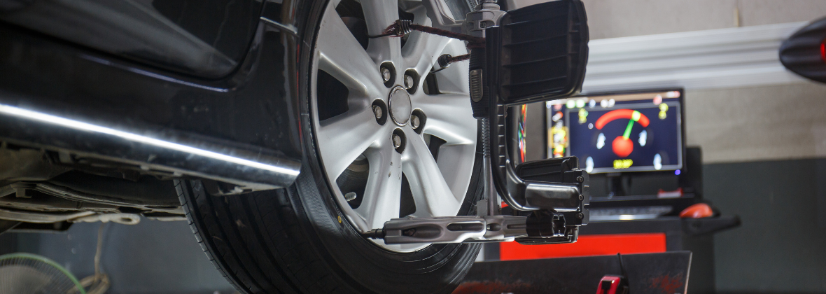 Car on stand with sensors on wheels for wheel alignment